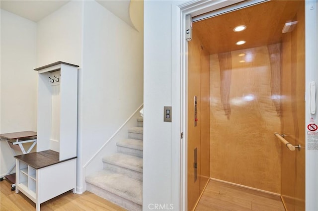 staircase featuring hardwood / wood-style floors and elevator