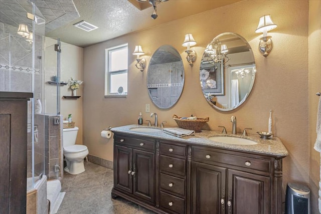 bathroom with tile patterned flooring, vanity, an enclosed shower, toilet, and a textured ceiling