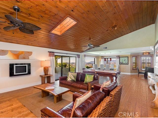 44665 La Cruz Dr, Temecula, CA 92590 - living area featuring ceiling fan, wood finished floors, wood ceiling, a skylight, and high vaulted ceiling