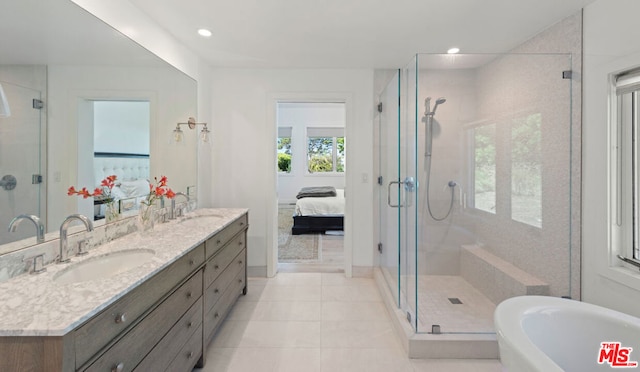 bathroom featuring plus walk in shower, tile patterned flooring, and vanity