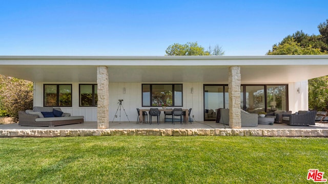 back of property with a lawn, outdoor lounge area, and a patio