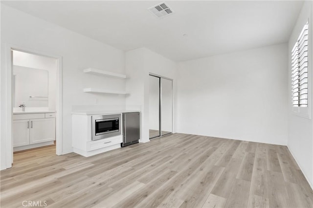 interior space featuring light hardwood / wood-style floors, white cabinetry, and stainless steel appliances