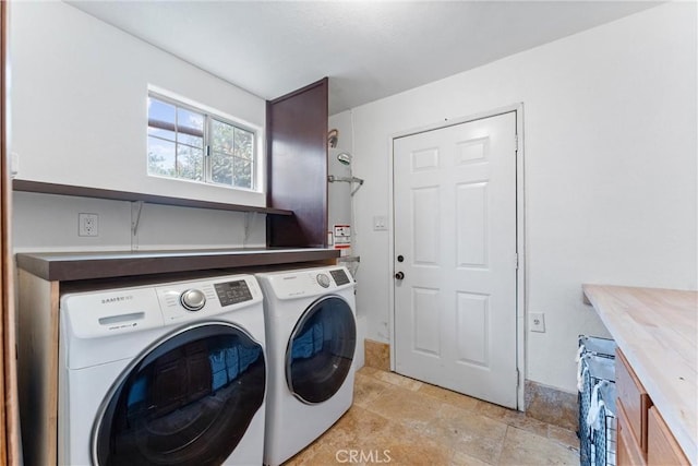 clothes washing area with cabinets and separate washer and dryer