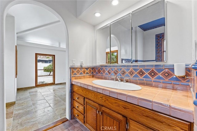 bathroom featuring vanity and tasteful backsplash