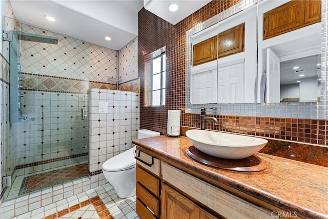 bathroom featuring tile patterned flooring, backsplash, toilet, vanity, and tile walls