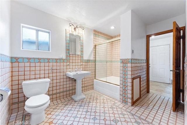 bathroom featuring shower / bathtub combination, toilet, and tile walls