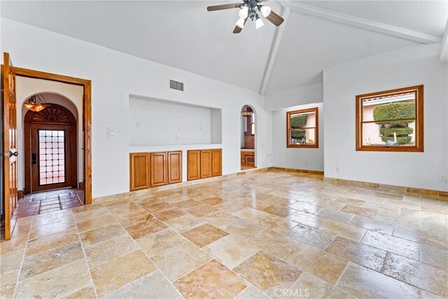 unfurnished living room with beam ceiling, high vaulted ceiling, and ceiling fan