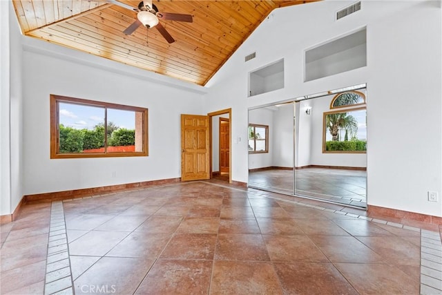 tiled empty room with ceiling fan, high vaulted ceiling, and wood ceiling