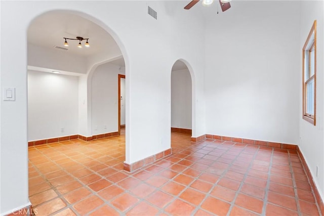 tiled spare room featuring ceiling fan