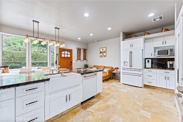 kitchen featuring pendant lighting, white appliances, white cabinetry, and sink