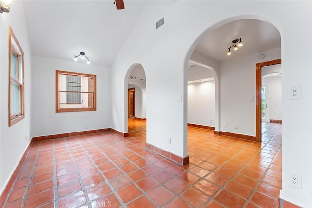 tiled empty room featuring a healthy amount of sunlight and lofted ceiling