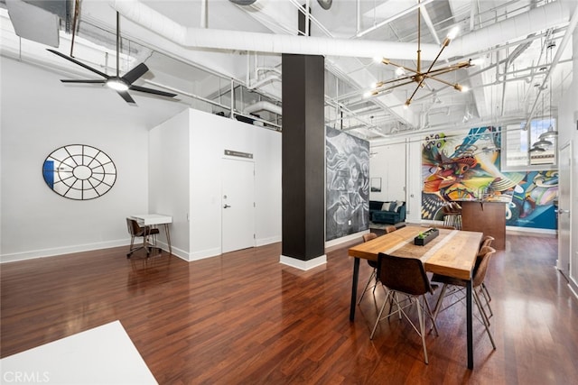 dining space featuring ceiling fan with notable chandelier, dark hardwood / wood-style flooring, and a towering ceiling