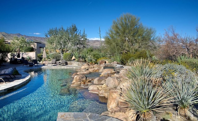 view of pool with a mountain view and a patio area