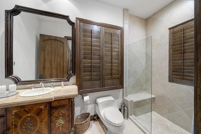 bathroom featuring a tile shower, vanity, and toilet