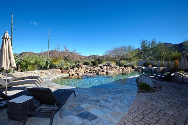 view of swimming pool featuring a patio area and a mountain view