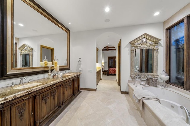 bathroom featuring tiled bath and vanity