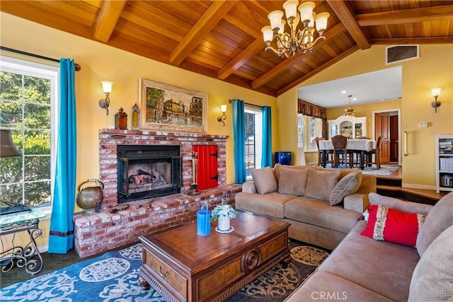 carpeted living room with an inviting chandelier, wooden ceiling, a brick fireplace, and vaulted ceiling with beams