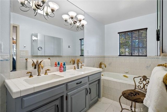bathroom featuring an inviting chandelier, vanity, and a relaxing tiled tub
