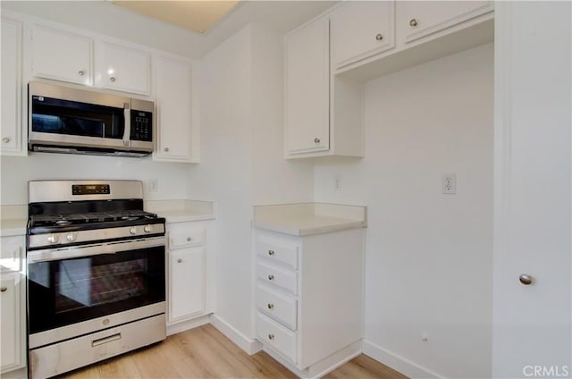 kitchen featuring white cabinets, stainless steel appliances, and light hardwood / wood-style floors