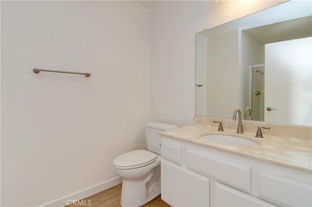 bathroom with toilet, vanity, and hardwood / wood-style floors