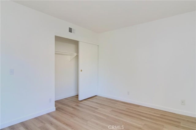 unfurnished bedroom featuring a closet and light hardwood / wood-style floors