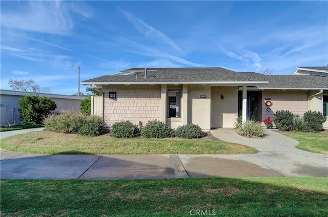 single story home featuring a front lawn