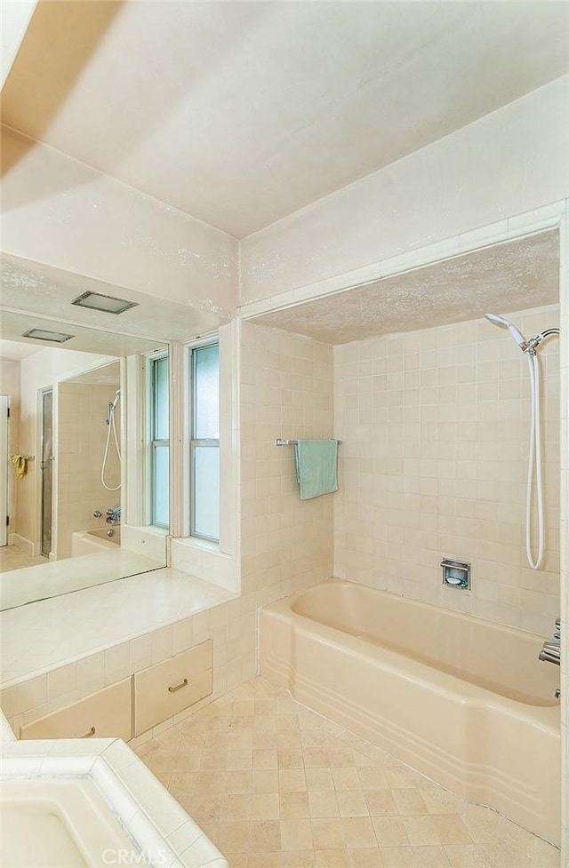 bathroom featuring tile patterned floors and tiled shower / bath combo