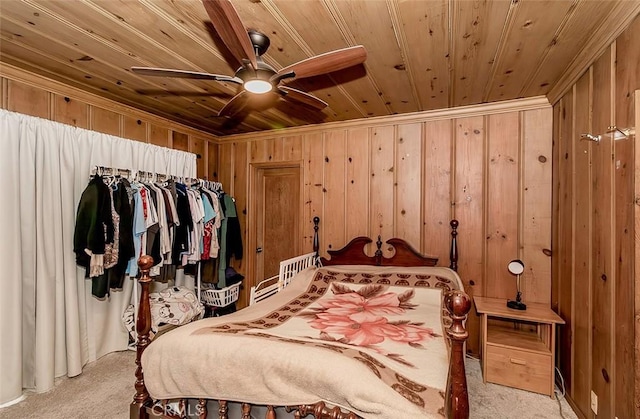 bedroom featuring light carpet, wooden ceiling, ceiling fan, and wooden walls