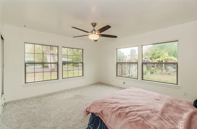 bedroom featuring carpet flooring, multiple windows, and ceiling fan