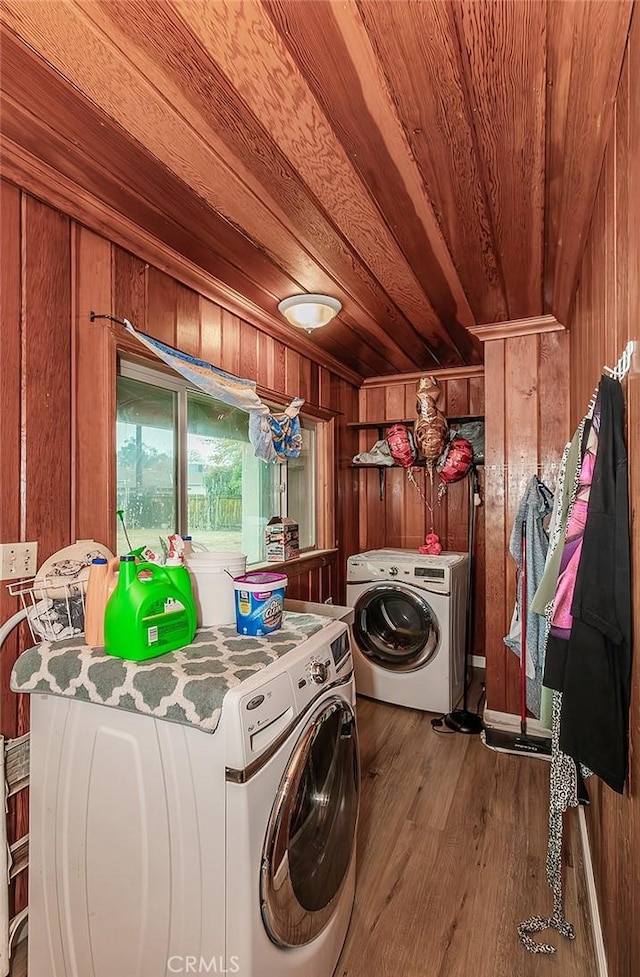 laundry room featuring washing machine and dryer, hardwood / wood-style flooring, wood ceiling, and wood walls