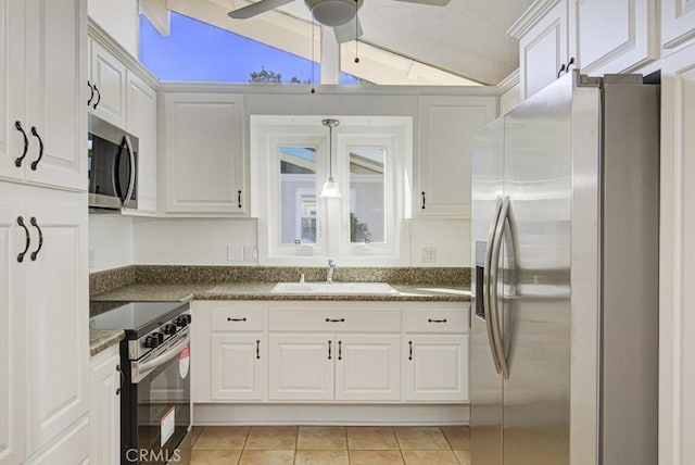 kitchen featuring white cabinets, sink, stainless steel appliances, and vaulted ceiling