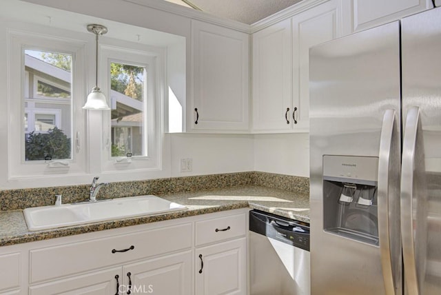 kitchen featuring sink, dark stone countertops, a textured ceiling, white cabinets, and appliances with stainless steel finishes