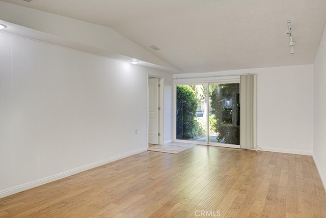 empty room featuring light hardwood / wood-style floors and vaulted ceiling