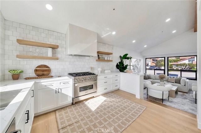 kitchen with white cabinetry, wall chimney exhaust hood, light wood-type flooring, decorative backsplash, and high end stainless steel range