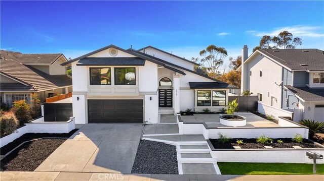 view of front of home featuring a garage and an outdoor fire pit