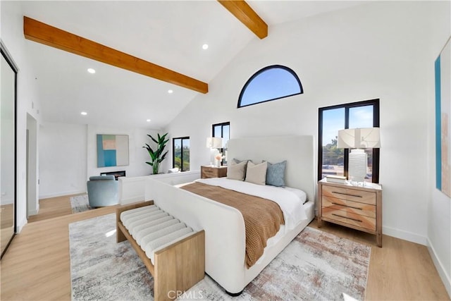 bedroom featuring high vaulted ceiling, light hardwood / wood-style flooring, and beamed ceiling