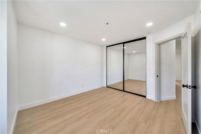 unfurnished bedroom featuring a closet and light hardwood / wood-style floors