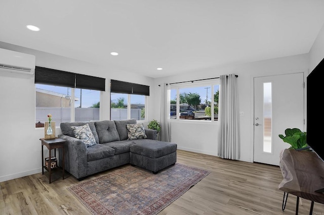 living room featuring light wood-type flooring and a wall mounted air conditioner