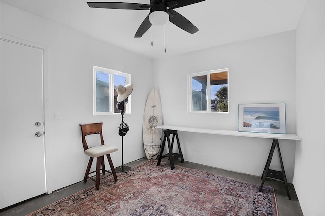 interior space featuring ceiling fan, concrete flooring, and plenty of natural light