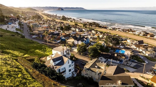 birds eye view of property featuring a water view and a beach view