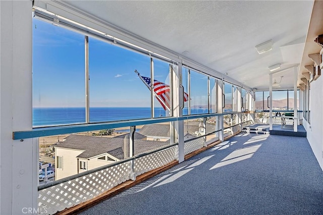 sunroom featuring a water view