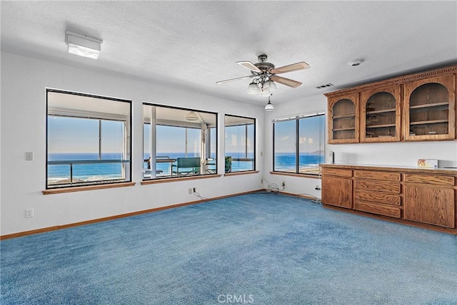 kitchen with ceiling fan, carpet, and a water view