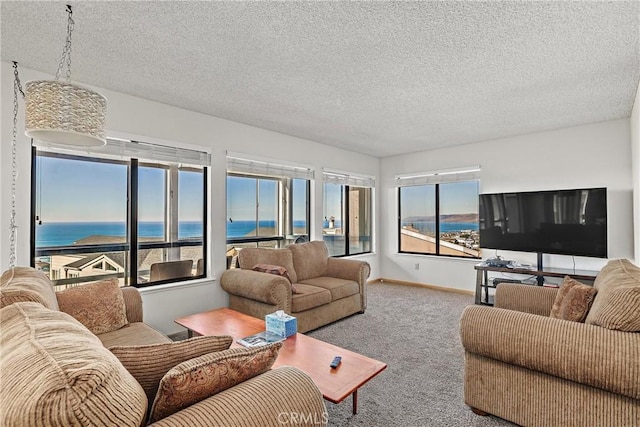 living room featuring plenty of natural light, a textured ceiling, carpet, and a water view