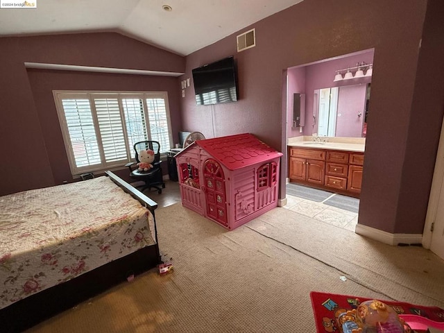 bedroom featuring ensuite bathroom, sink, light colored carpet, and lofted ceiling