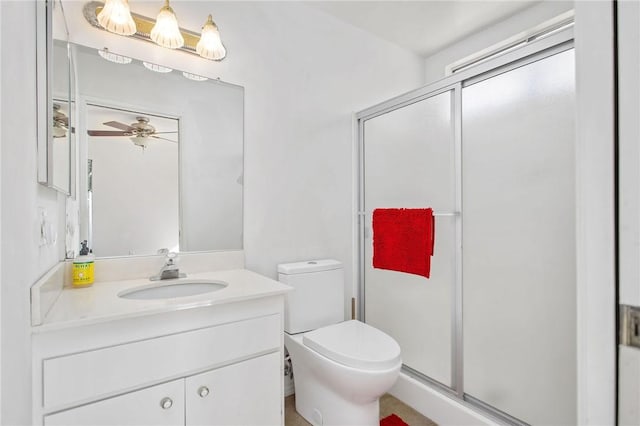 bathroom with vanity, ceiling fan, a shower with shower door, and toilet