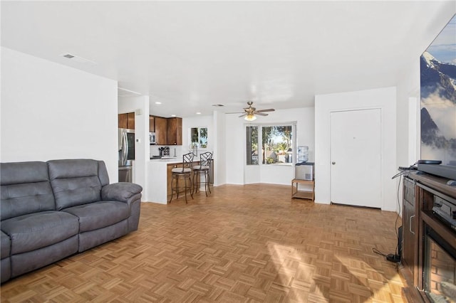 living room with ceiling fan and light parquet flooring