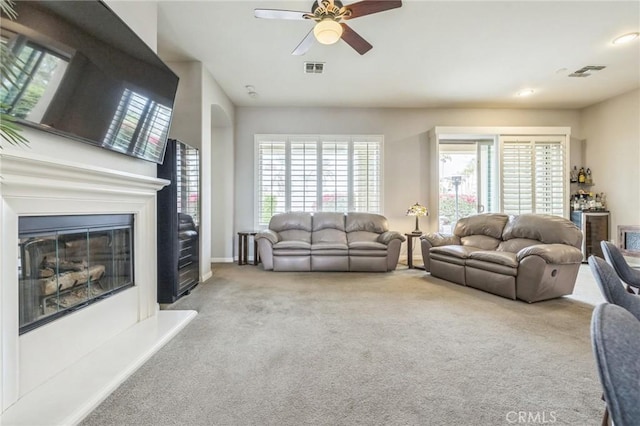 carpeted living room with ceiling fan