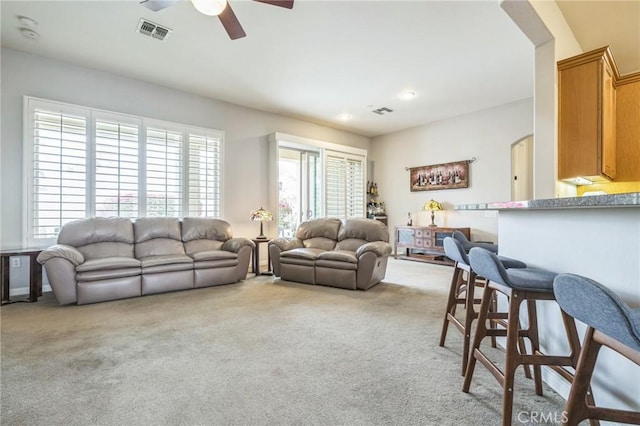 living room featuring ceiling fan and light colored carpet