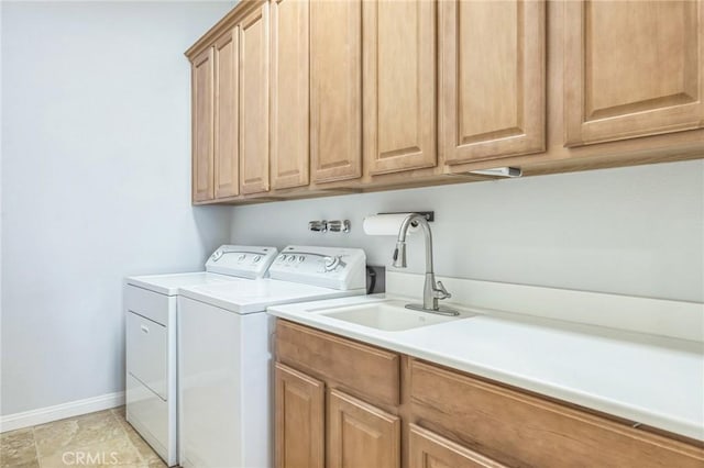 washroom with washer and dryer, sink, and cabinets