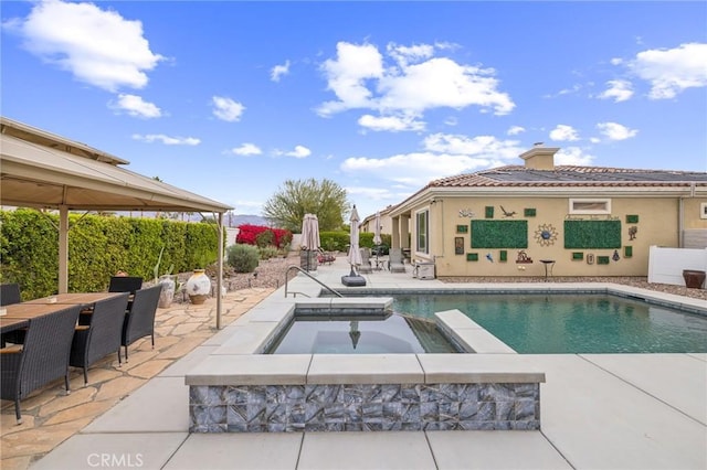 view of swimming pool featuring an in ground hot tub and a patio